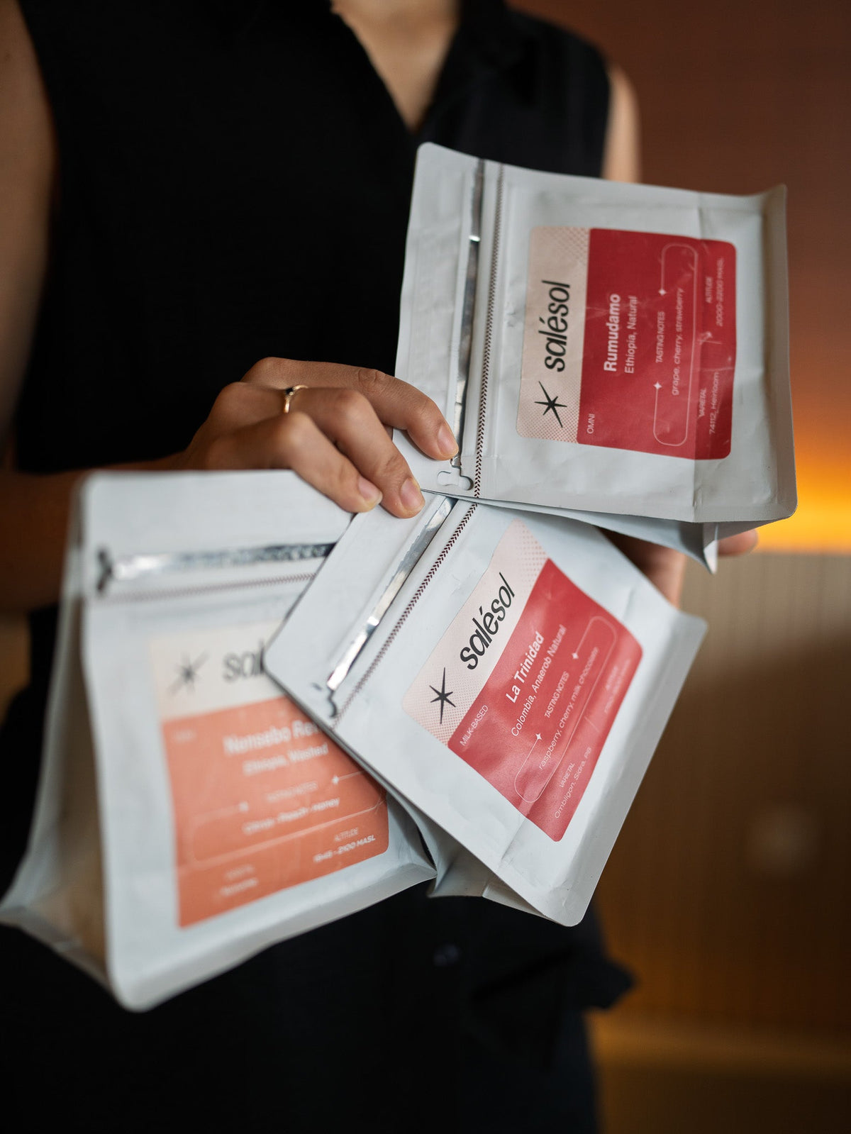 Three Salésol coffee bags held up together: Rumudamo, La Trinidad and Nensebo Refisa. The Rumudamo label lists its variety as 74112, Heirloom.